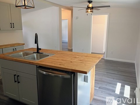 A kitchen with a wooden countertop and a stainless steel dishwasher.