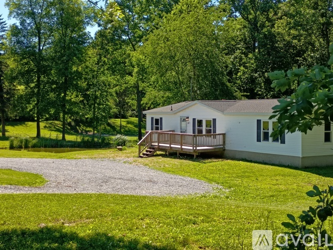 A house with a gravel driveway in front of it.