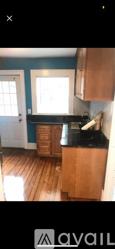 A kitchen with wooden floors and a black countertop.