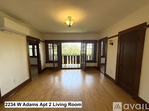 A living room with wood flooring and a large window.