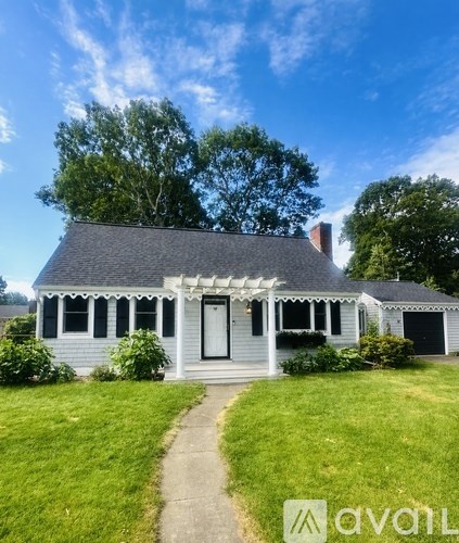 A white house with a black door and a small porch.