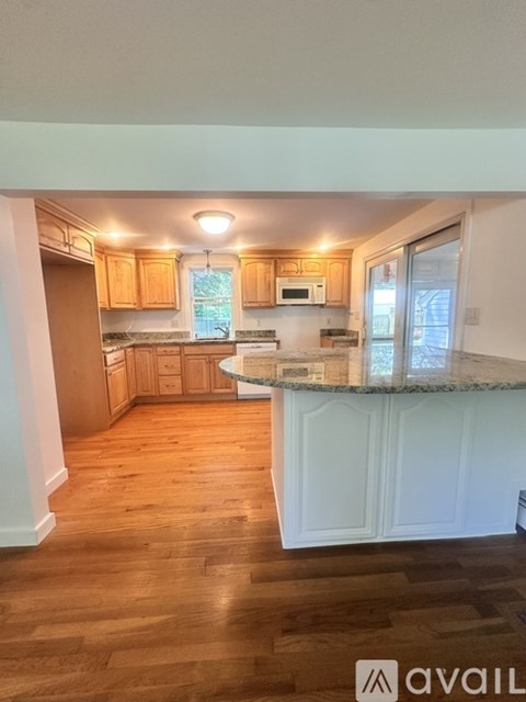 A kitchen with wooden floors and white cabinets.