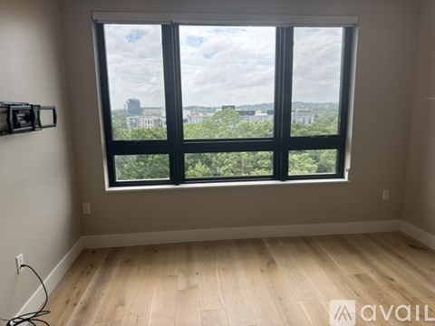 A room with a large window overlooking a cityscape.