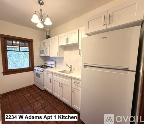 A kitchen with white appliances and cabinets.