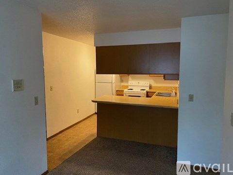 A kitchen area with a white oven and brown cabinets.
