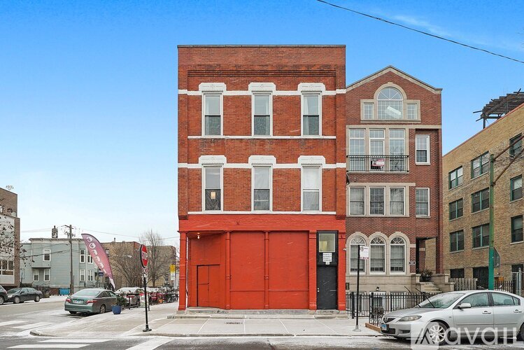 A red brick building with a red garage door in front.