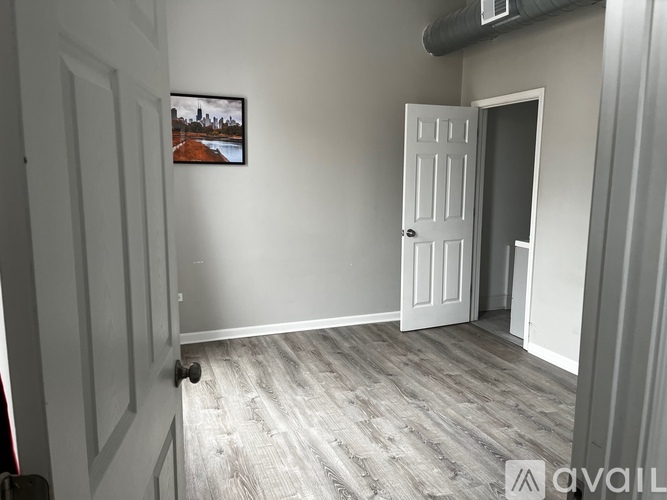 A room with a white door and a framed picture on the wall.