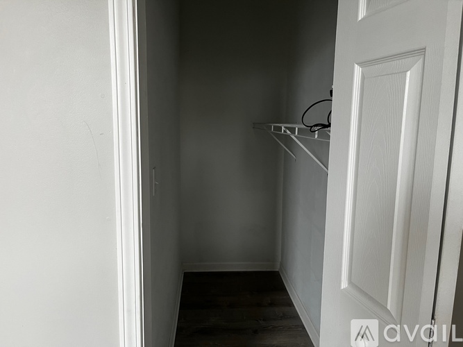 A white door is on the right side of a hallway.