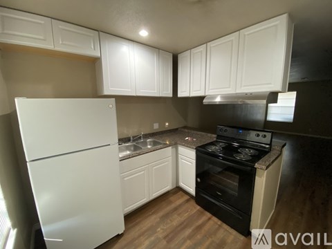 A kitchen with white cabinets and a black stove top oven.