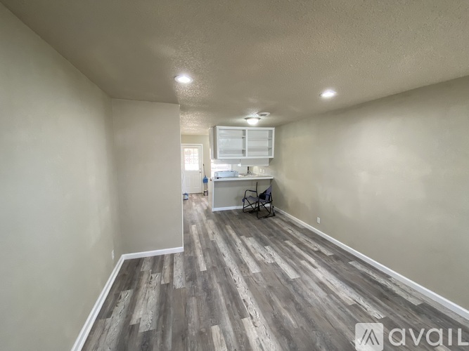 A room with wooden flooring and a white cabinet.