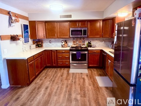 A kitchen with wooden cabinets and a stove top oven.