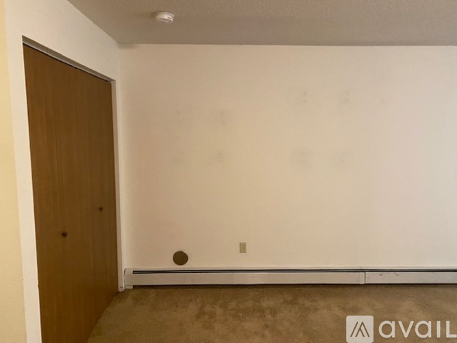 A room with a brown door and a white wall.
