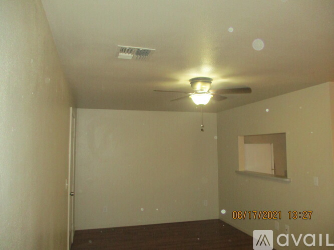 A room with a ceiling fan and a window.