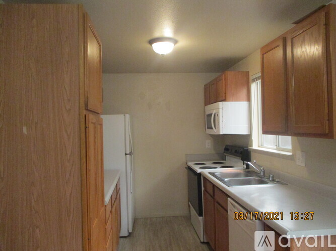 A kitchen with wooden cabinets and a white refrigerator.
