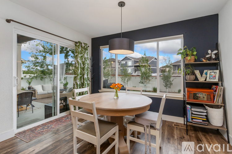 A dining room with a table and chairs and a view of the outside.