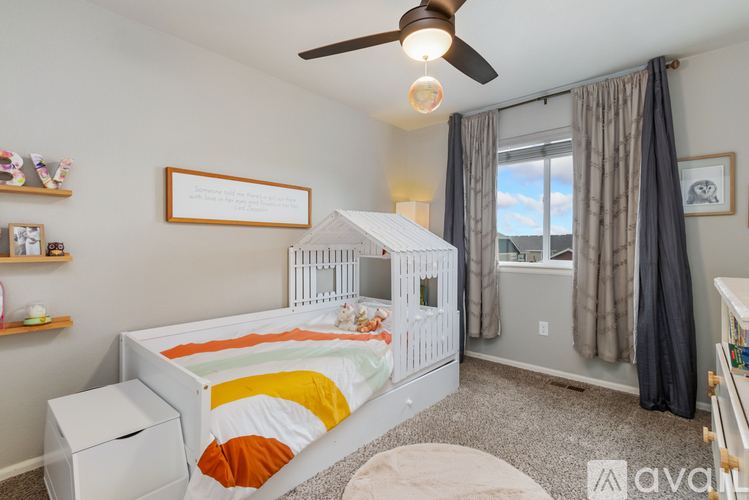 A child's bedroom with a white bed and a ceiling fan.