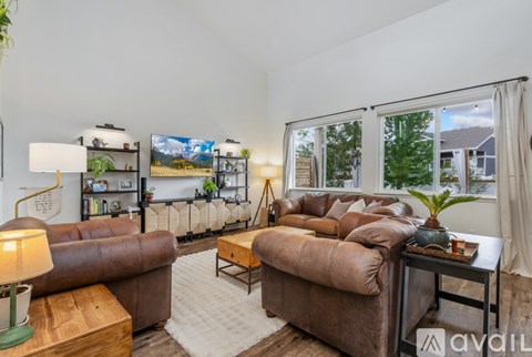 A living room with a brown leather couch and a wooden coffee table.