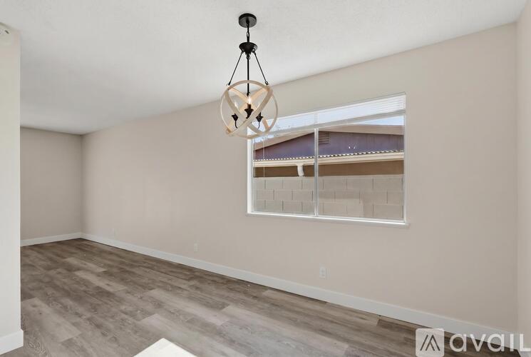A room with a large window and a hanging light fixture.