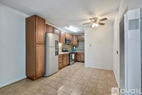 A kitchen with a refrigerator, microwave, and oven.
