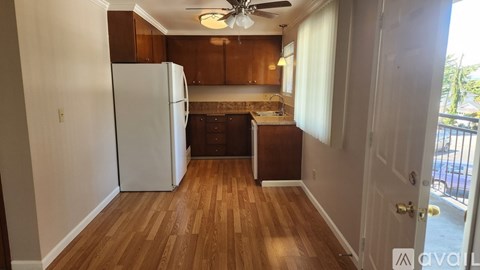 A kitchen with a white refrigerator and wooden floors.