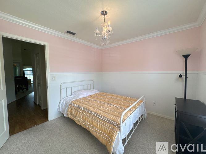A bedroom with a bed and a chandelier.