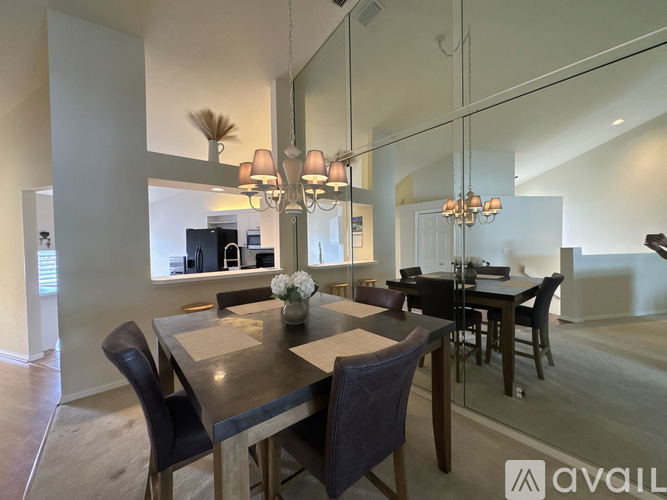 A modern dining room with a large table and chairs.
