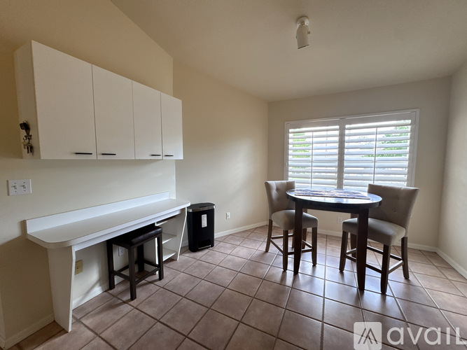 A kitchen area with a table and chairs.