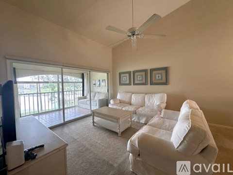 A living room with a white couch and a television.