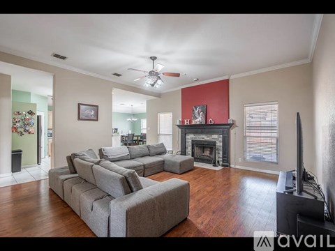 A living room with a grey sofa and a fireplace.