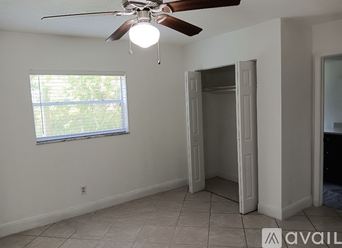 A room with a ceiling fan and a window.