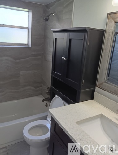 A white toilet sits next to a bathtub in a bathroom.