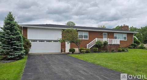 A house with a garage and a driveway in front of it.