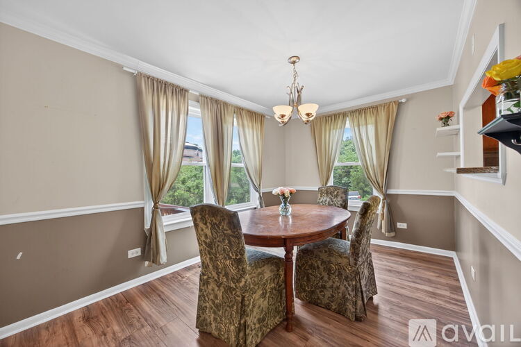 A dining room with a round table and chairs.