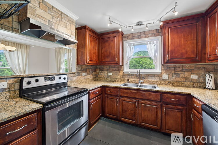 A kitchen with wooden cabinets and a stainless steel oven.