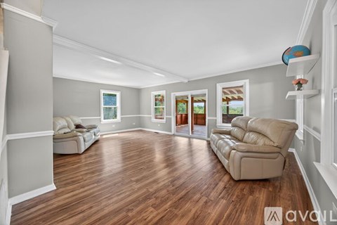 A living room with a beige couch and wooden flooring.
