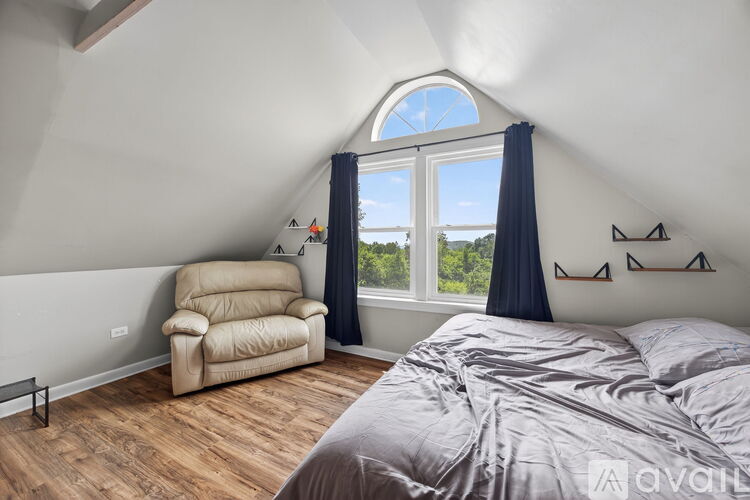 A bedroom with a large bed and a chair.