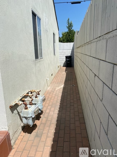 A long brick walkway between two white walls.