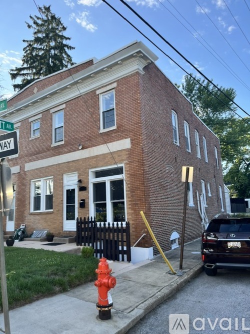 A red fire hydrant is in front of a brick building.