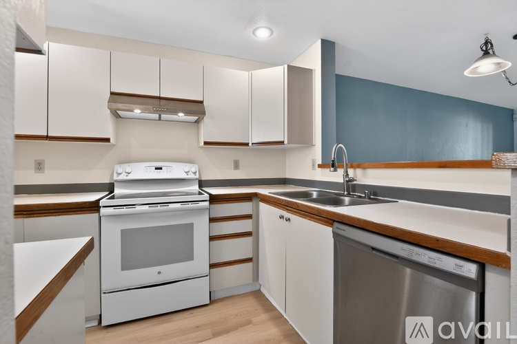 A kitchen with white appliances and wooden accents.