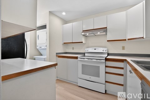 A modern kitchen with white cabinets and a wooden counter.