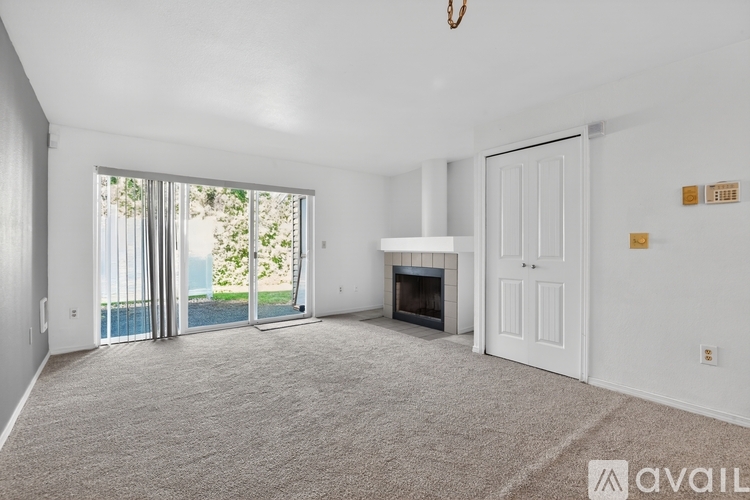 A spacious living room with a fireplace and sliding glass doors leading to a pool.
