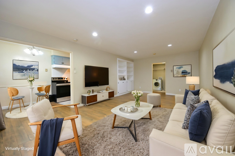 A living room with a white couch, a wooden chair, and a coffee table.
