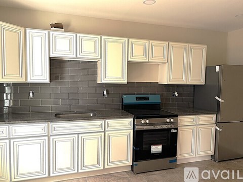 A kitchen with white cabinets and a black oven.
