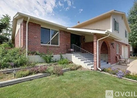 A house with a red brick exterior and a white trim is for sale.