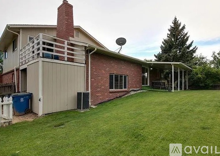 A house with a red brick chimney and a balcony on the second floor.