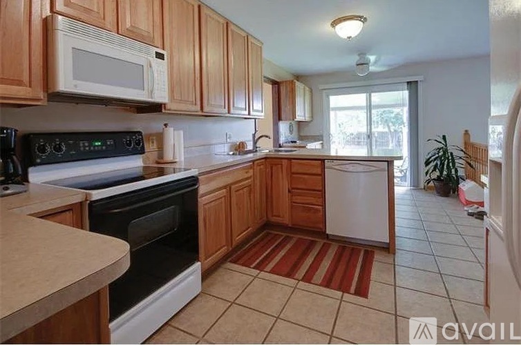 A kitchen with wooden cabinets and a black stove top oven.
