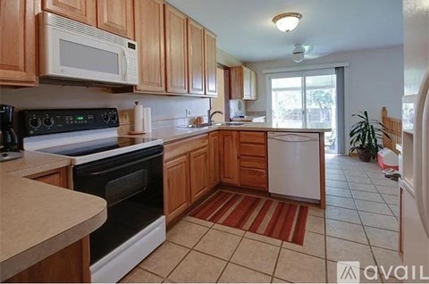 A kitchen with wooden cabinets and a black stove top oven.
