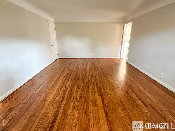 A room with wooden flooring and white walls.