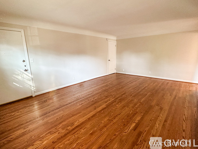 A room with wooden flooring and white walls.