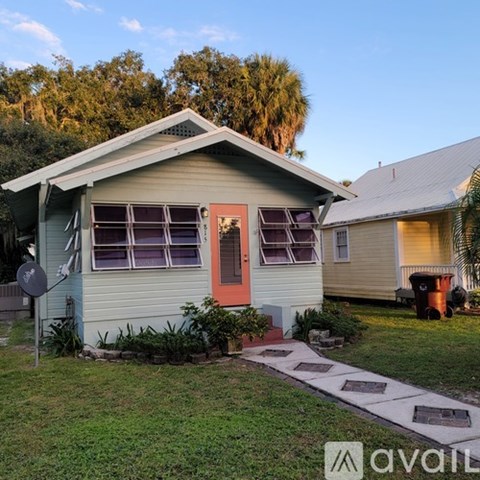 A house with a red door and a satellite dish on the left.